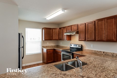 a kitchen with granite counter tops and wooden cabinets
