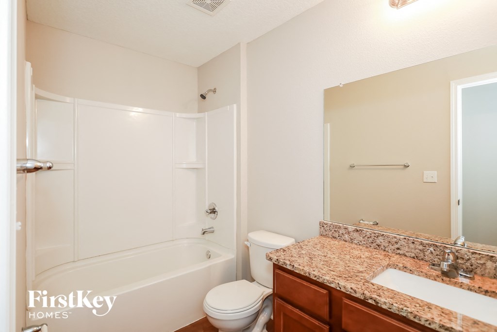 a bathroom with a shower toilet and sink and a mirror