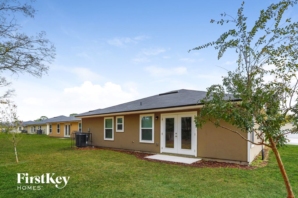 a row of houses with a grassy yard and trees