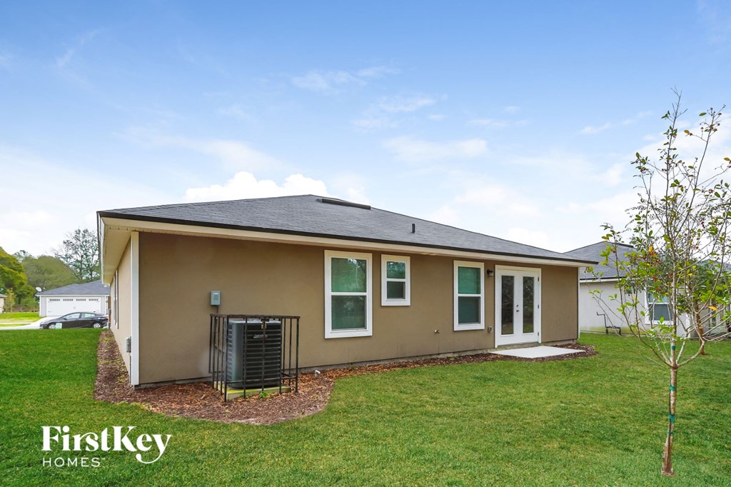 a small brown house with a yard and grass