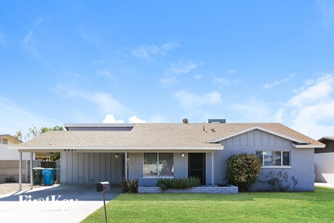 a white house with a lawn and a blue sky