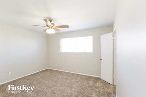 a bedroom with a ceiling fan and a door to a closet