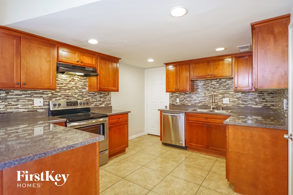 a kitchen with wooden cabinets and stainless steel appliances