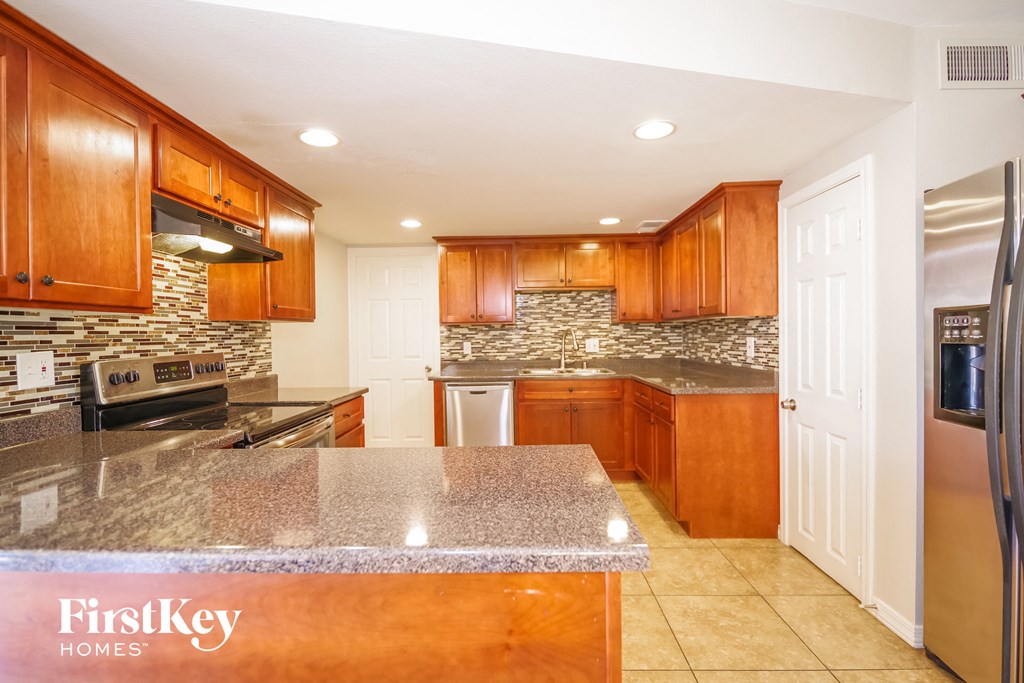 full view of kitchen with granite countertops and stainless steel appliances