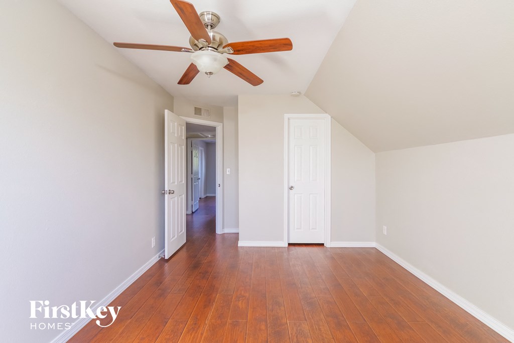 a living room with wood floors and a ceiling fan