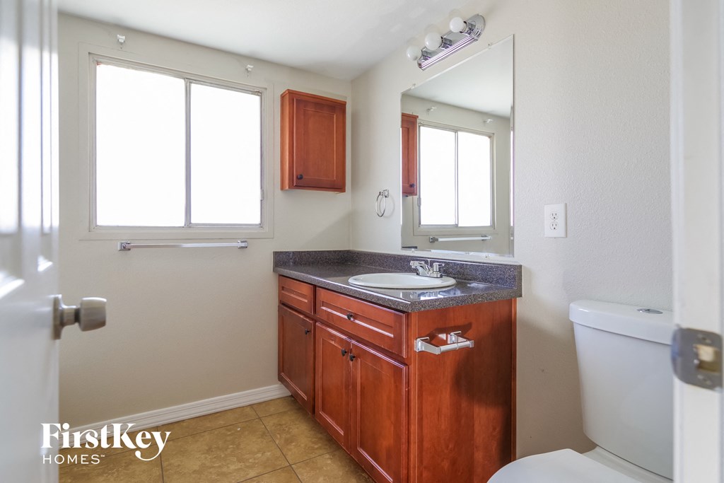 a bathroom with a sink toilet and a mirror