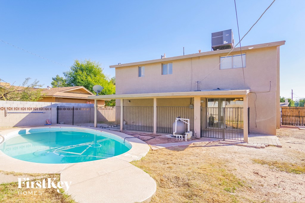 a backyard with a pool and a house with a hot tub
