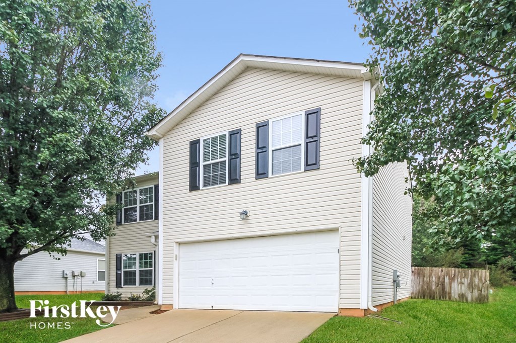 the front of a white house with a white garage door