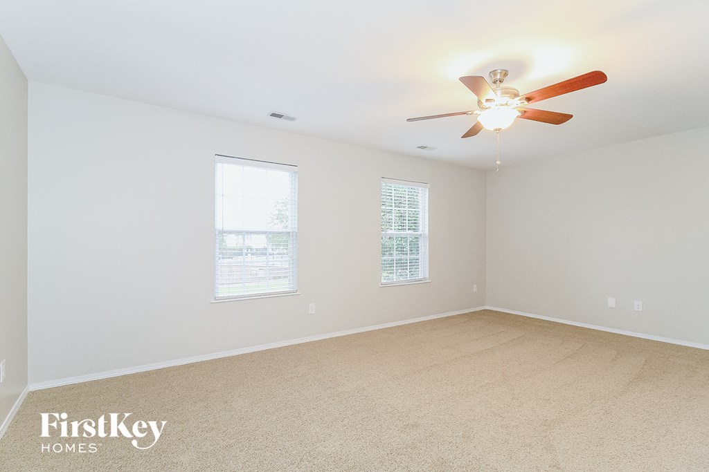 a bedroom with white walls and a ceiling fan
