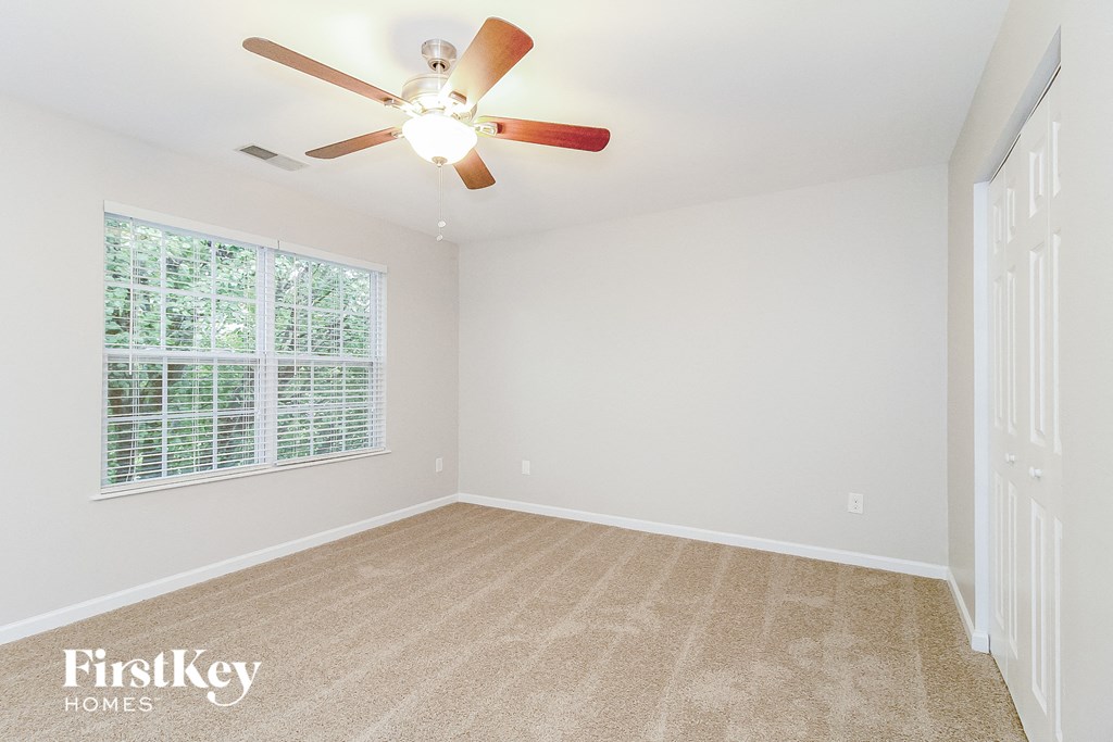 a bedroom with a ceiling fan and a window