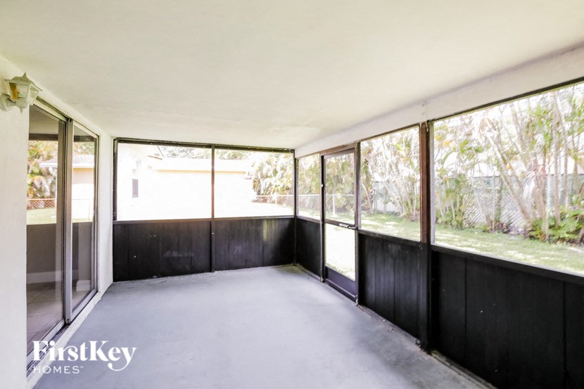 an empty room with large windows and a concrete floor