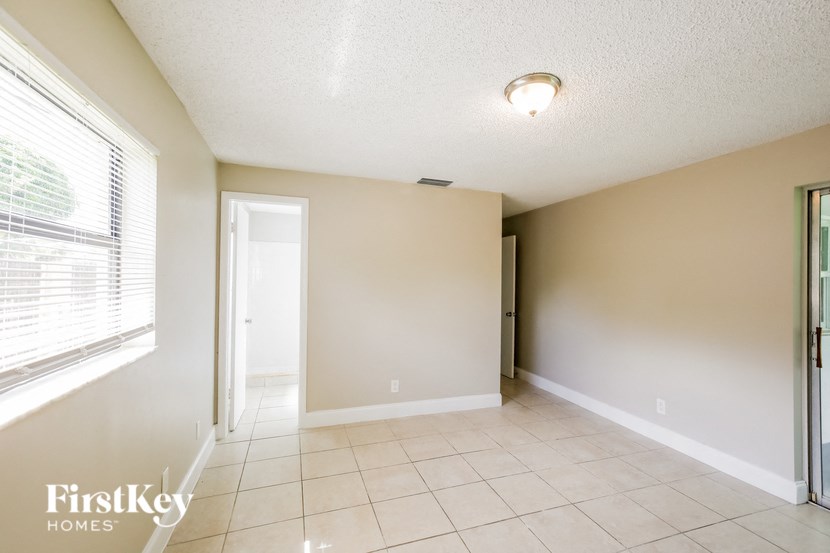 the living room and dining room of an empty house with a large window