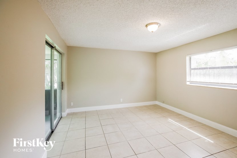 an empty living room with a sliding glass door to a patio