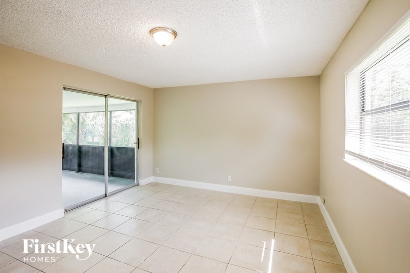 an empty living room with sliding glass doors to a patio