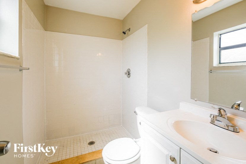 a bathroom with a sink toilet and a mirror