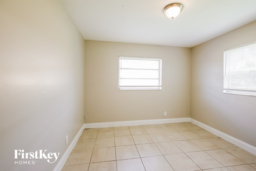an empty room with a window and tiled floors
