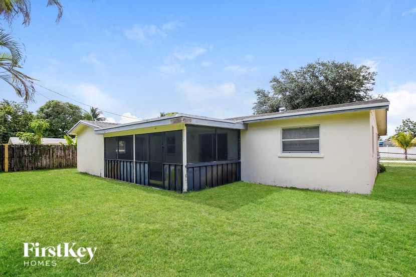 a small house with a yard and a screened in porch