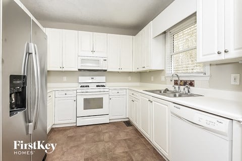a white kitchen with white cabinets and white appliances