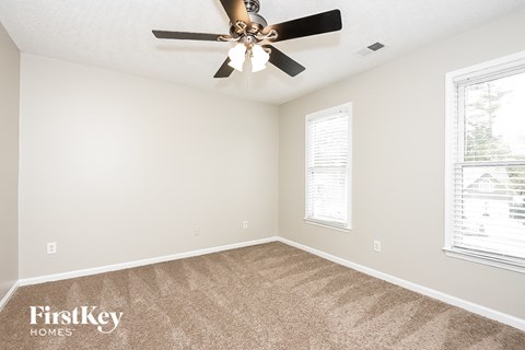 a bedroom with carpet and a ceiling fan