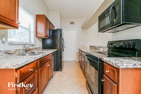 A kitchen with a black fridge and black oven.