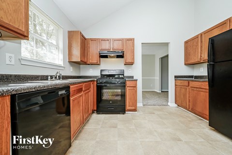 A kitchen with wooden cabinets and black appliances.