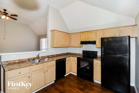 A kitchen with wooden cabinets and black appliances.
