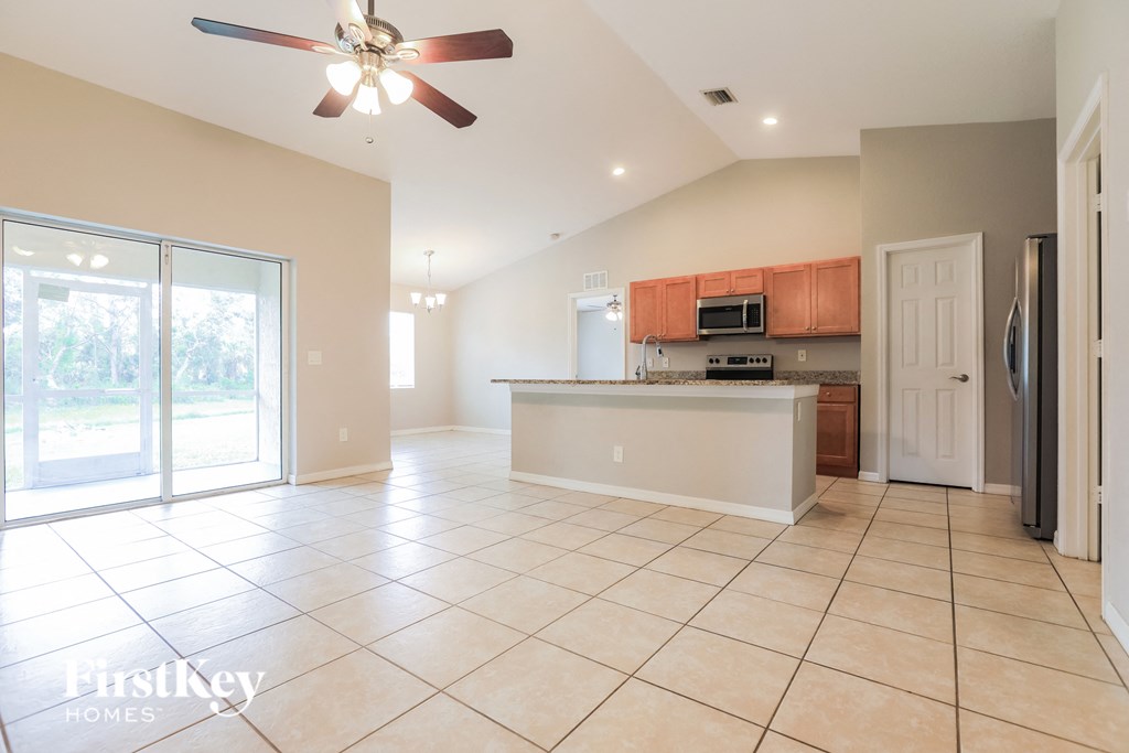 A spacious kitchen with a fan on the ceiling.