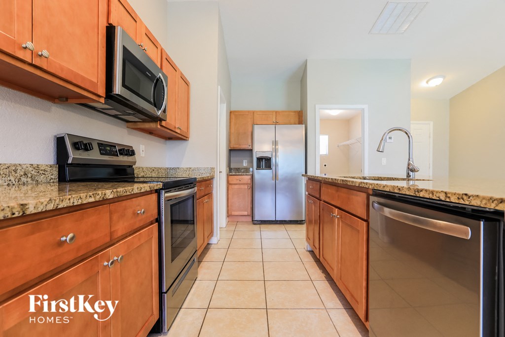 A kitchen with wooden cabinets and a stainless steel refrigerator.