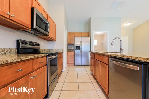 A kitchen with wooden cabinets and a stainless steel refrigerator.
