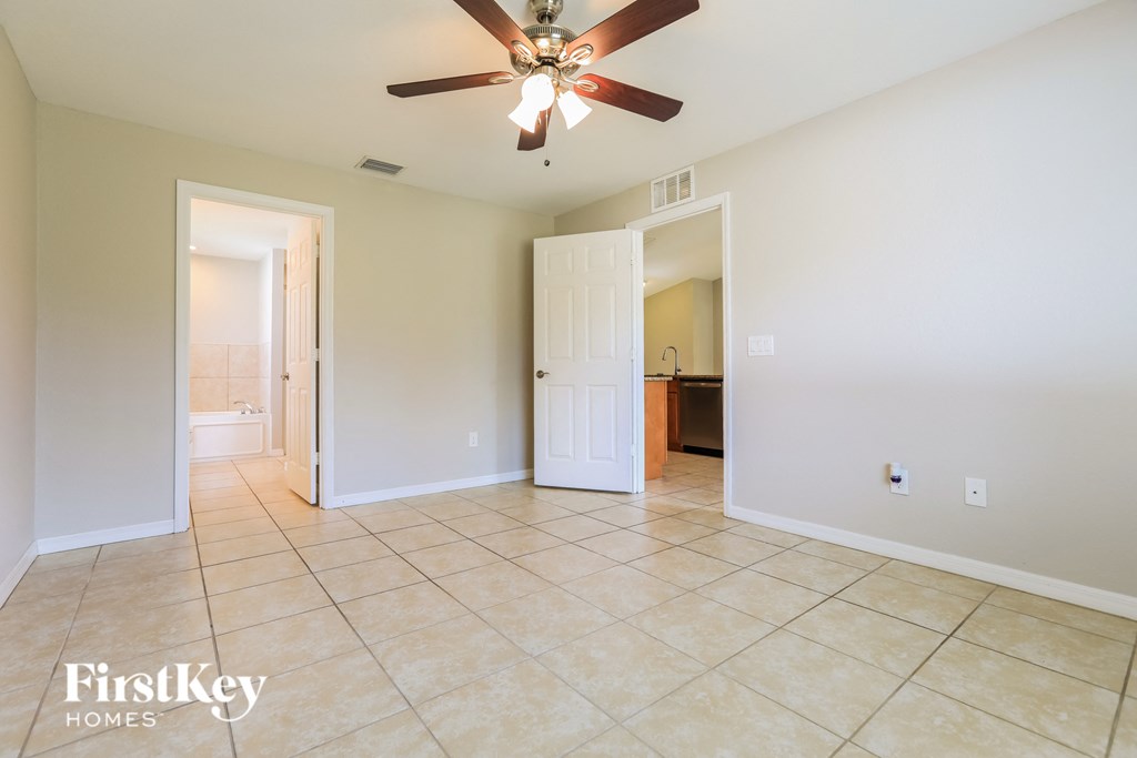 A spacious room with a ceiling fan and tile flooring.