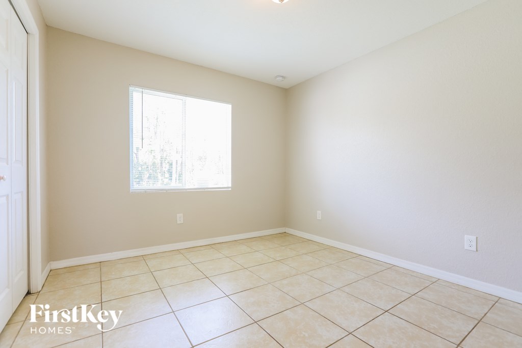 A room with a window and tiled floor.