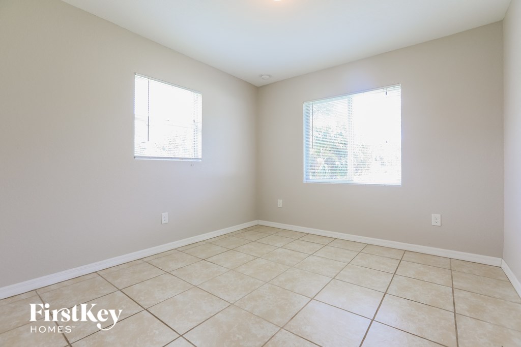 A room with two windows and a tiled floor.