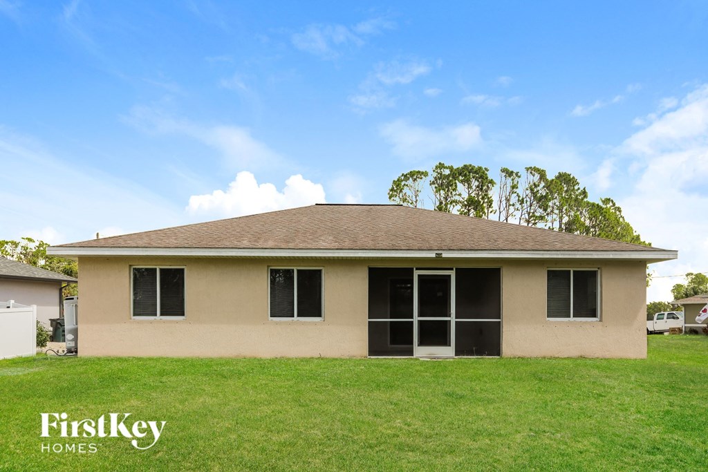 A house with a brown roof and a sign that says "FirstKey Homes" in front of it.