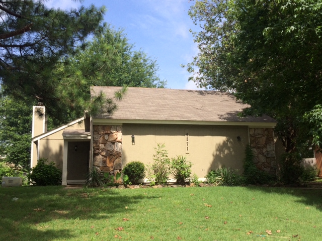 a house with a lawn and trees in front of it