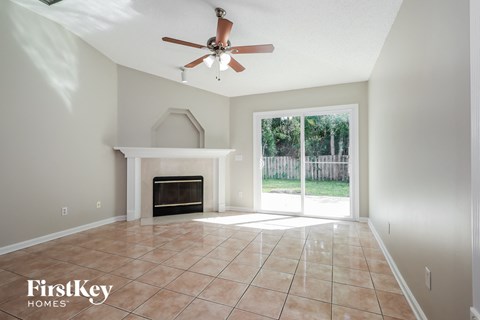 A spacious room with a fireplace and a ceiling fan.