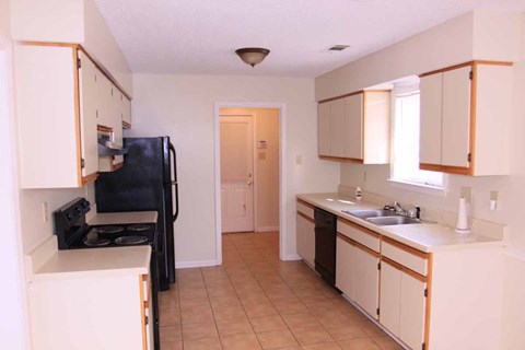 a kitchen with white cabinets and a sink and a refrigerator