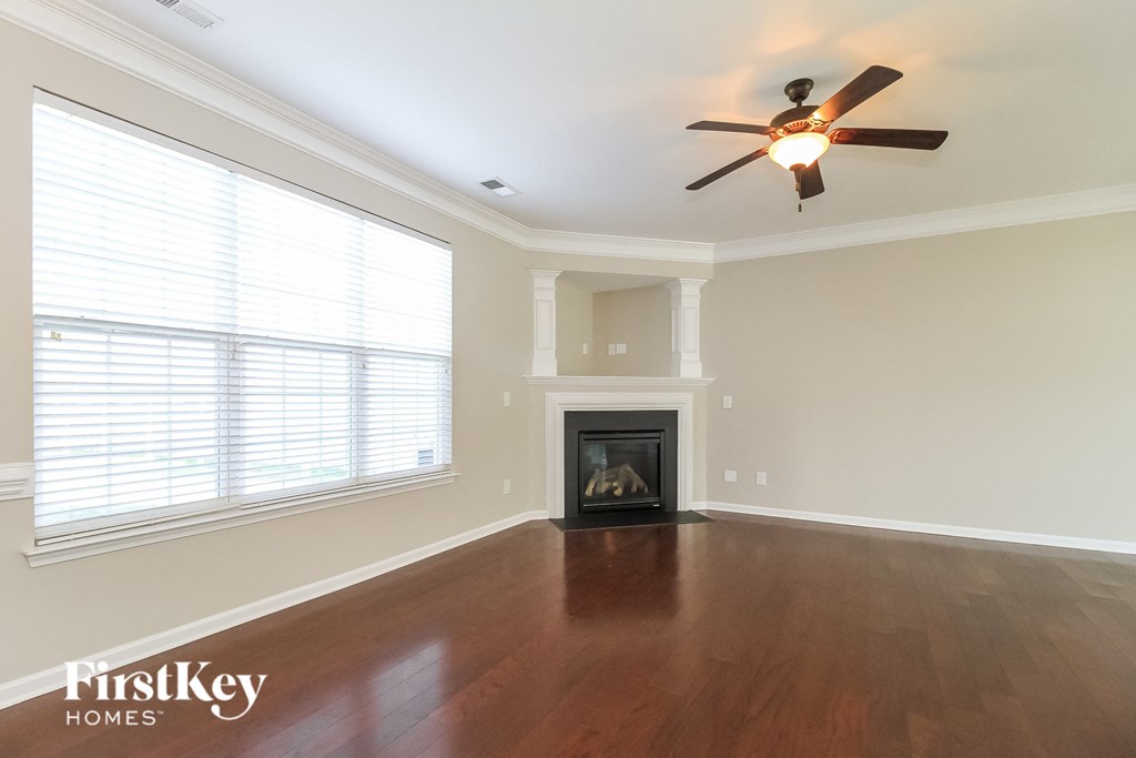 a living room with a ceiling fan and a fireplace