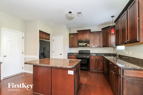 a kitchen with wood cabinets and granite counter tops and black appliances