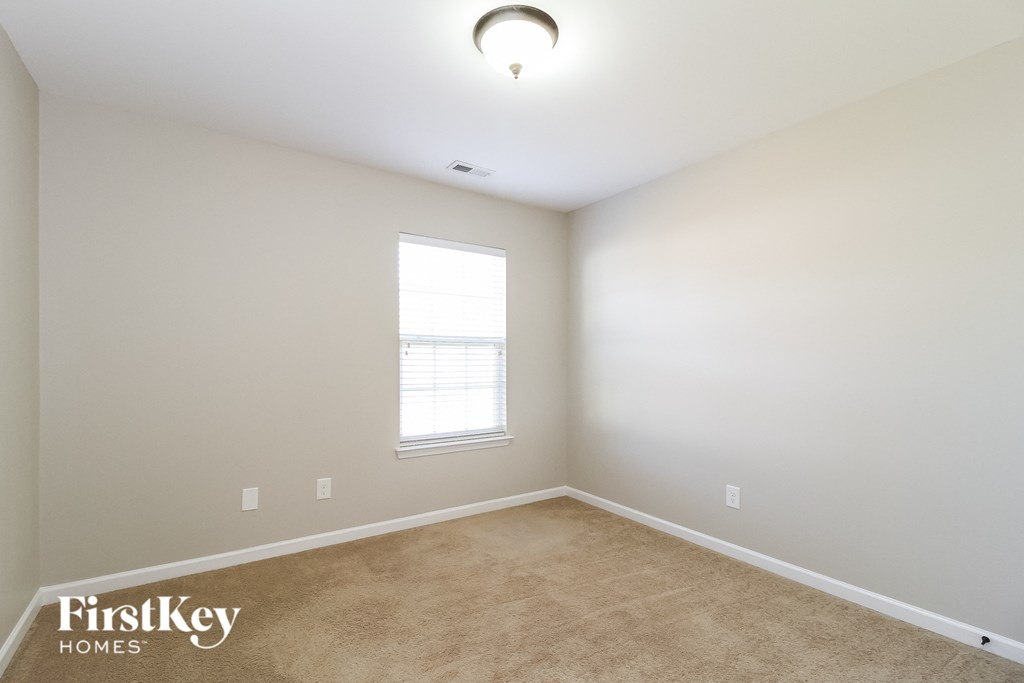 a bedroom with a carpeted floor and a window