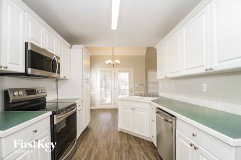 a kitchen with white cabinets and a green counter top