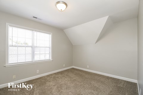 the living room of a home with carpet and a window