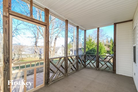 a screened porch with a view of the yard and trees