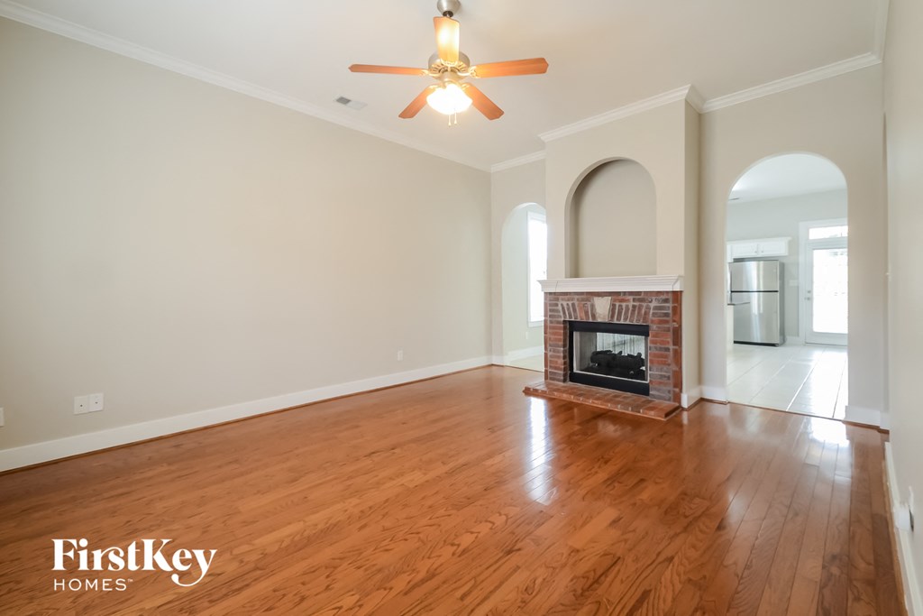A room with a fireplace and a ceiling fan.