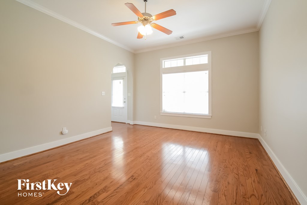 A room with wooden floors and a ceiling fan.
