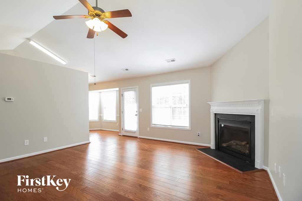 a living room with a fireplace and a ceiling fan