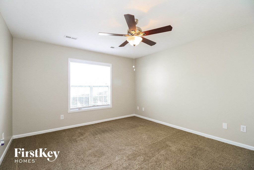a bedroom with carpet and a ceiling fan
