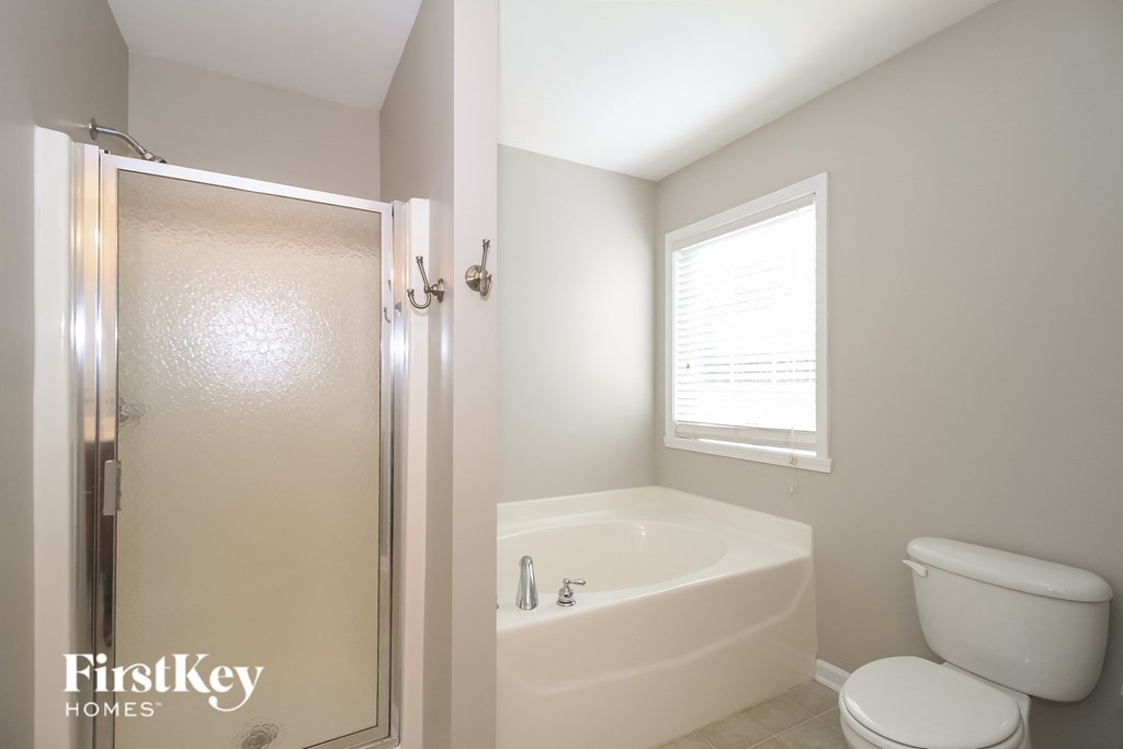 a bathroom with a toilet and a tub and a shower