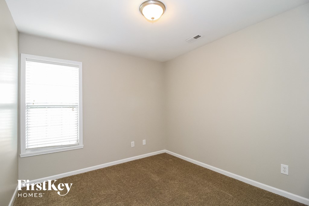 a bedroom with a carpeted floor and a window