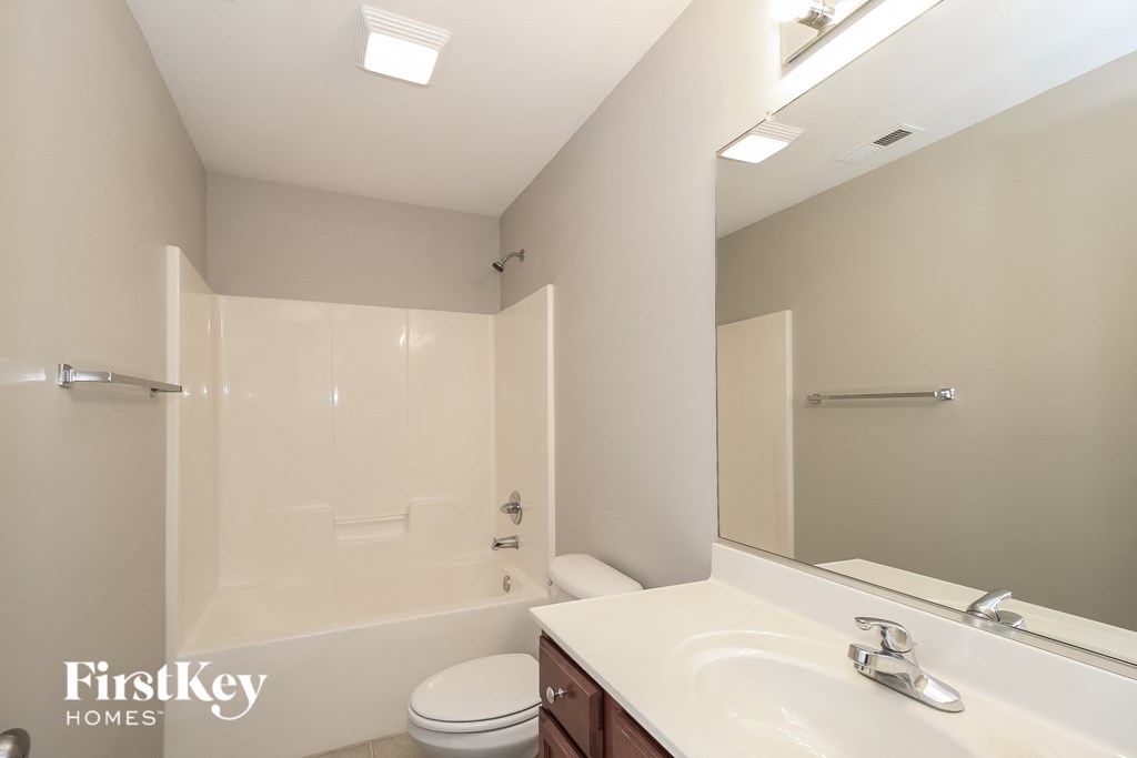 a bathroom with a white sink and a shower and a toilet