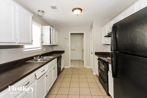 a kitchen with white cabinets and black appliances and a black refrigerator